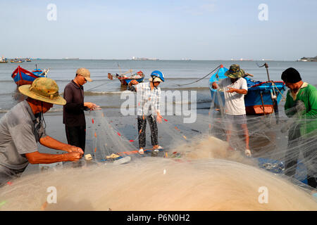 Fischer Instandsetzung Fischernetze bei Tam Duong Strand. Vung Tau. Vietnam. Stockfoto