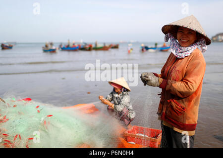 Fischer Instandsetzung Fischernetze bei Tam Duong Strand. Vung Tau. Vietnam. Stockfoto