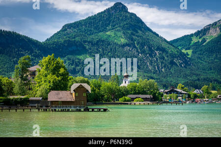 Bootshaus am Wolfgangsee mit Bergen im Hintergrund und Wolken am Himmel Stockfoto