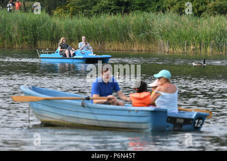 Die Menschen in den Booten im Regent's Park, London, so viel von dem Vereinigten Königreich weiterhin einen Zauber der warmen Wetter zu genießen. Stockfoto