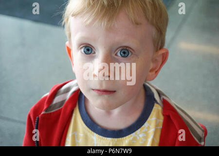 Schöne erstaunte blaue Augen vier Jahr Junge schaut in die Ferne überrascht. Lustige und niedliche Kinder portrait Konzept Stockfoto