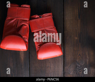 Paar rote Leder Handschuhe für Boxen auf einem braunen Holzbrett, kopieren Raum Stockfoto