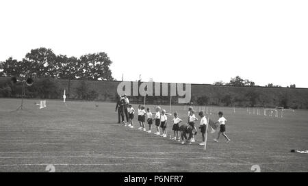 1950er Jahre, Grundschule Sport Tag ... Jungen Futter bis auf dem Rasen vor dem Start der traditionellen Sprint laufende Rennen, England, UK. Stockfoto