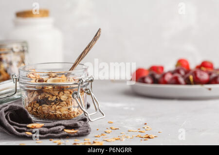 Hausgemachte Hafer Müsli in Gläsern mit Cherry und Milch. Gesunde Ernährung Konzept. Stockfoto