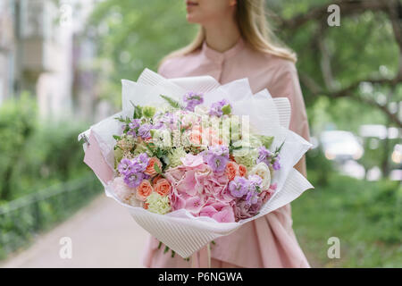 Junge Mädchen, dass einen schönen Sommer Bouquet. Blumenarrangement mit Hortensien und Pfingstrosen. Das Konzept der ein Blumengeschäft. Inhalt für den Katalog Stockfoto