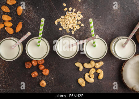 Vegane alternative Mutter Milch in Glasflaschen auf einem dunklen Hintergrund. Gesunde vegane Ernährung Konzept. Stockfoto