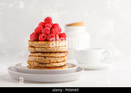 Vegane Pfannkuchen mit Himbeeren und Chia Samen auf eine weiße Platte, weisser Hintergrund. Gesunde vegane Ernährung Konzept. Stockfoto