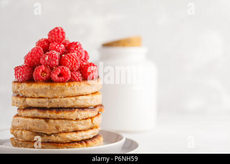 Vegane Pfannkuchen mit Himbeeren und Chia Samen auf eine weiße Platte, weisser Hintergrund. Gesunde vegane Ernährung Konzept. Stockfoto