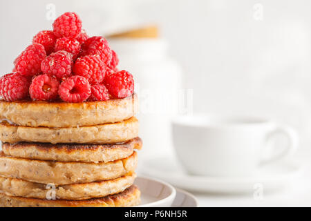 Vegane Pfannkuchen mit Himbeeren und Chia Samen auf eine weiße Platte, weisser Hintergrund. Gesunde vegane Ernährung Konzept. Stockfoto