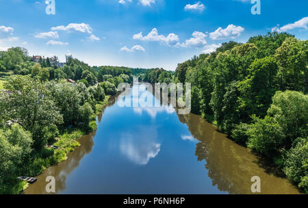 Wasserlauf der Luznice Fluss in Tabor, Südböhmen, Europa. Die malerische Landschaft. Wasser und Spiegelung, blauer Himmel und weiße Wolken. Üppige Bäume. Stockfoto