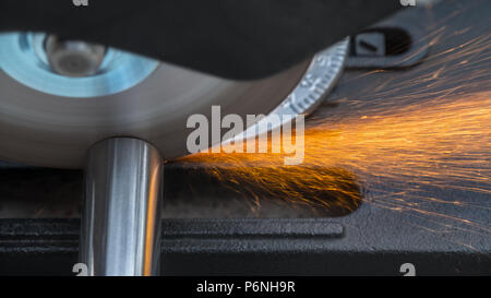 Schneiden eines metallischen Stange durch eine Kreissäge. In der Nähe von heißen Funken beim Sägen von Stahl Werkstück. Bewegungsunschärfe der Disc mit der scharfen Klinge. Stockfoto