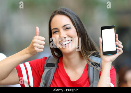 Happy Teen zeigt eine leere Smart phone Screen mit Daumen hoch Stockfoto