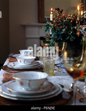 Close-up Vintage china Suppenschüsseln auf Weihnachten ein Tisch zum Abendessen mit brennenden Kerzen und festliches Blumenarrangement eingerichtet Stockfoto