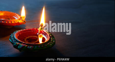 Happy Diwali - Nahaufnahme von lit Diya Lampen auf dem Boden Stockfoto