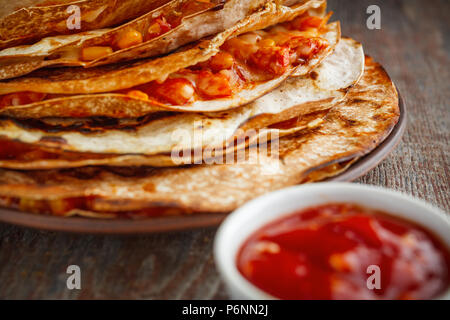 Mexikanische quesadilla, buritto oder fajito und Salsa Soße auf einer hölzernen Tisch Stockfoto