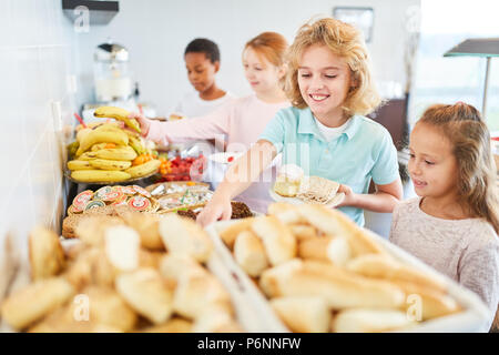 Schüler in der Volksschule Abholung Obst am Buffet in der Cafeteria Stockfoto