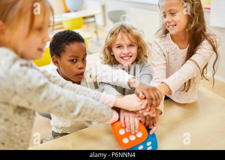 Multikulturelle Kinder als Freunde und Studenten stack Hände für Integration Stockfoto