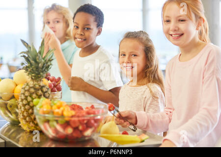 Multikulturelle Gruppe von Kindern in der Grundschule buffet Obst nehmen Stockfoto