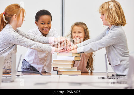 Multikulturelle Kinder Gruppe Stapel Hände zu Motivation in der Volksschule Stockfoto