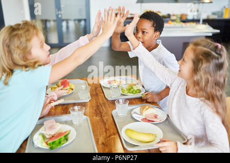 Kinder als Freunde haben Sie Spaß in der Schulkantine Mittag Stockfoto