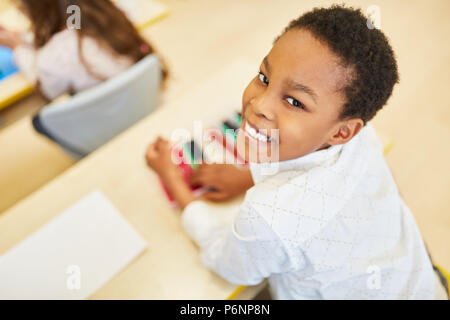 Afrikanischen Jungen als vorschulkind oder elementare Student ist glücklich in der Klasse Stockfoto