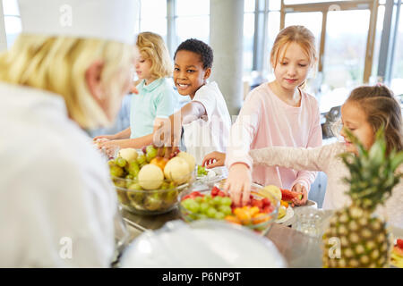 Die Schüler in der Cafeteria oder Kantine buffet frisches Obst erhalten Stockfoto