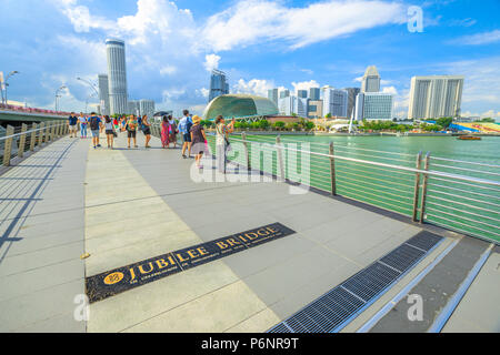 Singapur - 28. April 2018: Weitwinkelaufnahme der Jubilee Bridge. Esplanade oder Theater an der Bucht, die auch als die Durian und moderne Hochhäuser von Downtown auf Hintergrund bekannt. Sonnigen Tag blauer Himmel. Stockfoto