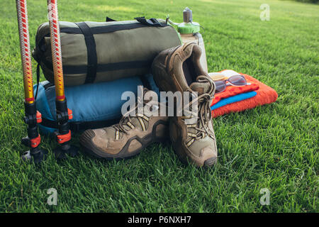 Trekking Schuhe, Schlafsäcke, Trekking, Wandern auf grünem Gras Stockfoto