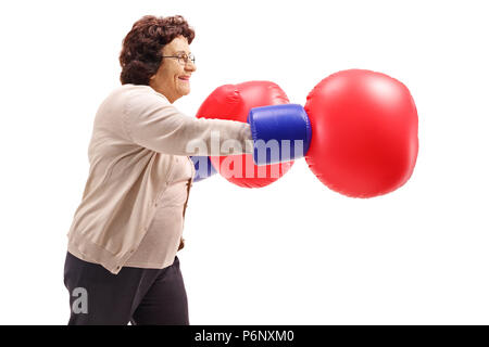 Ältere Frau mit ein paar grosse Boxhandschuhe auf weißem Hintergrund Stockfoto