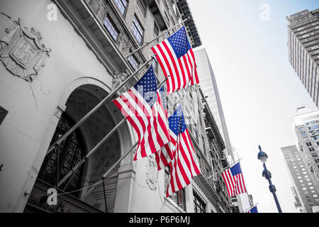 New York City, USA. Mehrere amerikanische Fahnen winken aus der Fassade eines Gebäudes Stockfoto