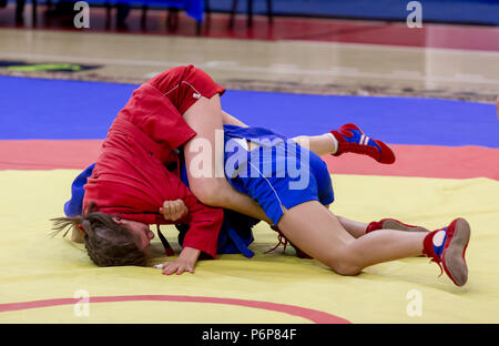 Zwei junge Mädchen konkurrieren im Wrestling auf Tatami. Wrestling Wettbewerb unter den Kindern. Jugend Turniere der Kampfkünste und Kampfsportarten. Stockfoto