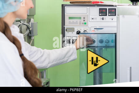 Frau Fertigungsingenieur für die Einstellungen für eine industrielle Maschine Stockfoto