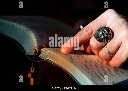 Mann mit Totenkopf Ring Lesen der Bibel. Frankreich. Stockfoto