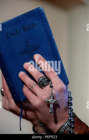 Mann mit Totenkopf Ring beten den Rosenkranz und das Lesen der Bibel. Close-up. Frankreich. Stockfoto