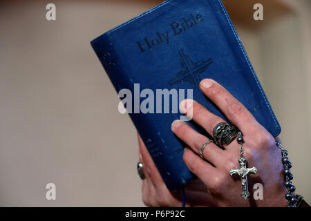 Mann mit Totenkopf Ring beten den Rosenkranz und das Lesen der Bibel. Close-up. Frankreich. Stockfoto