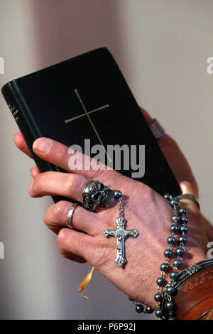 Mann mit Totenkopf Ring beten den Rosenkranz und das Lesen der Bibel. Close-up. Frankreich. Stockfoto