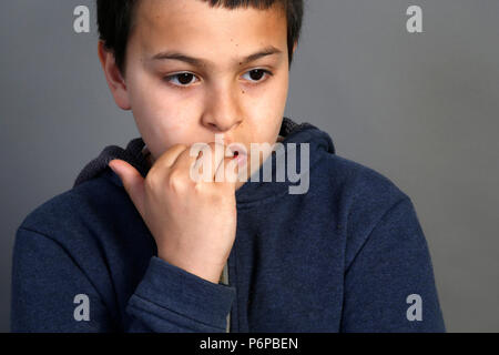 12-jähriger Junge Beißen seiner Nägel. Paris, Frankreich. Stockfoto