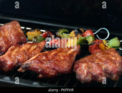 Barbecue Spare Ribs mit grünen und roten Paprika, dunklen Hintergrund für Kopie Raum Stockfoto