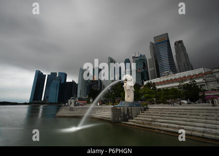 Singapur - May 24, 2018: Der Merlion Brunnen vor der Skyline von Singapur in den frühen Morgenstunden an einem stürmischen und bewölkten Tag. Stockfoto