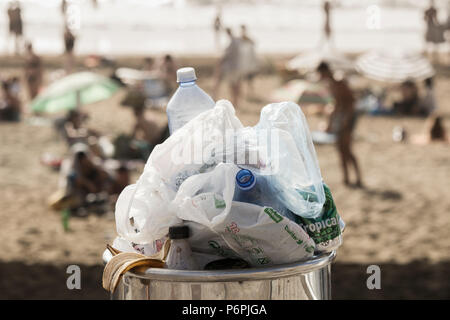 Überquellenden Abfallbehälter voll von Plastikflaschen und Tüten am Strand Stockfoto