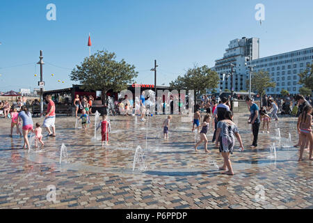 Kinder spielen in den Wasserfontänen am Fountain Square, Folkestone Harbour, Kent, Großbritannien Stockfoto