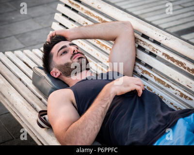 Attraktiven jungen Mann ruht auf Holz Werkbank Stockfoto