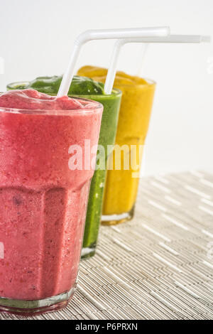 Smoothies von Farben mit Himbeeren, Heidelbeeren, Banane, Ananas, Mango, Rucola und Apple in ein Glas mit Sorbet serviert. Stockfoto