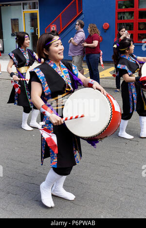 Junge japanische Kanadische Frauen schlagen die Trommeln in der jährlichen Canada Day Parade auf Granville Island, Vancouver, British Columbia. Stockfoto