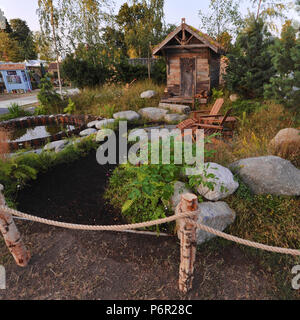 London, Großbritannien. 2. Juli 2018. Die Viking Kreuzfahrten Nordic Lifestyle Garten (von Stephen Hall) Eine der schönen und eleganten Gärten zeigen, die auf der 2018 RHS Hampton Court Flower Show, die heute auf dem Gelände der Hampton Court Palace, London, Großbritannien, 02. Juli 2018 eröffnet. Neuerstellen eines Nordischen Waldgebiet führt ein Pfad zu Stein Sitzbereich neben der traditionellen Sauna Hütte gepflastert. Nordic Stein Geröll führen dann zu einem Tauchbecken, gesäumt mit Kopfsteinpflaster und kleinen Felsbrocken. Größere Felsbrocken scheinen durch Bereiche der wiese gras rund um die Sauna wächst, während die Nordischen Bäume und Sträucher Stockfoto