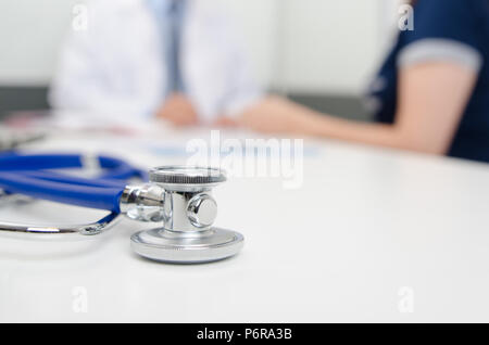 Stethoskop hautnah. Patient und Arzt im Büro. Doktor schreibt das Rezept im Hintergrund Stockfoto