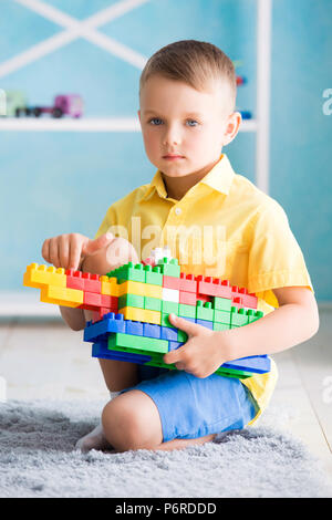 Junge spielt in Würfel und die Designer des Hauses Stockfoto