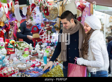 Glückliche junge Mann mit Freundin am Counter von X-mas Markt. Flache Fokus Stockfoto