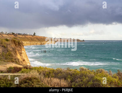 Gewitterwolken über der Küste von St. Vincent Gulf über den Port Willunga Kalkfelsen und der Port Willunga Jetty Pylone, SA, Australien Stockfoto