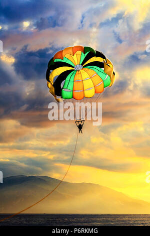 Parasailing über Oriental Mindoro gegen dramatische Himmel am White Beach, Puerto Galera, Philippinen. Stockfoto